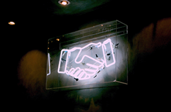 neonskylt som visar ett handslag